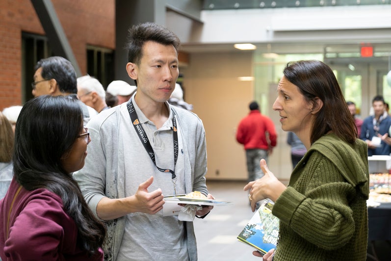 Three people in conversation at a reception. 