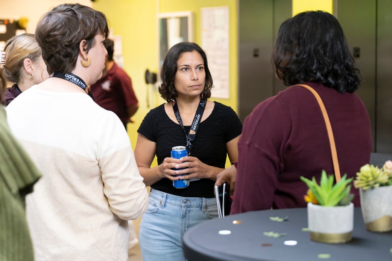 Three people in conversation at a reception. 