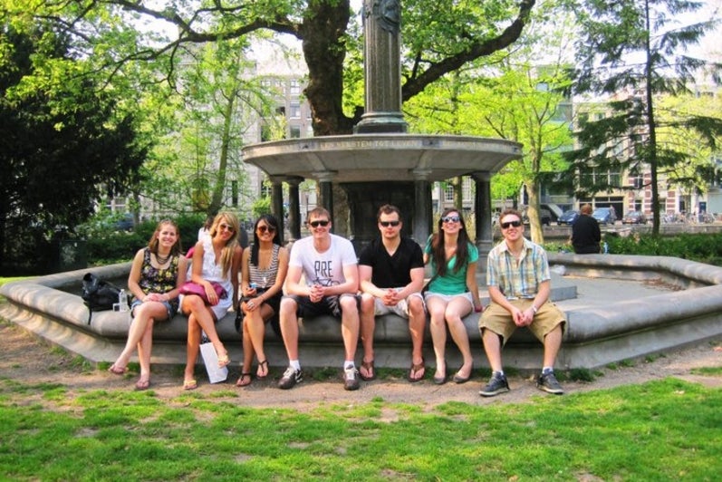 Students sitting in front of a fountain