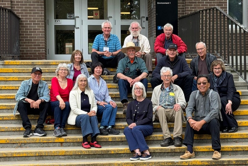 A group of people sitting on steps in front of a building.
