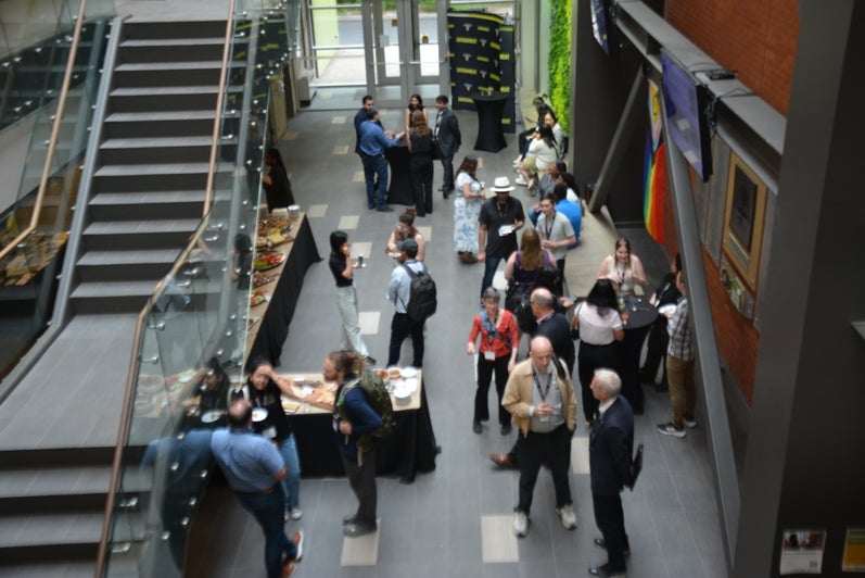 people socializing in an open atrium beside a staircase