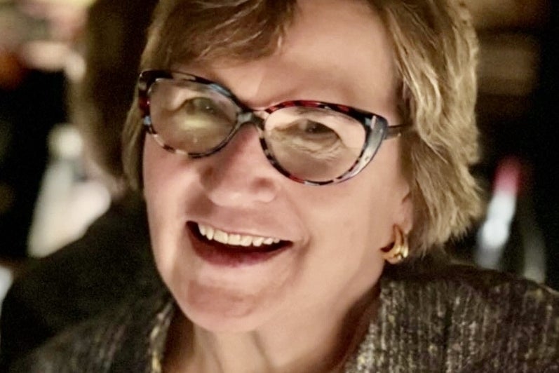 woman with glasses and short brown hair smiles.