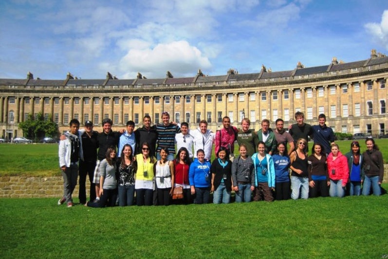 Students posing in front of historic building 
