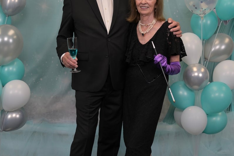 Man and woman in formal wear hold champaign glasses