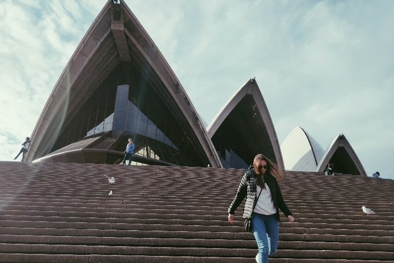 Girl walking down the steps in front of the Opera House in Sydney, Australia