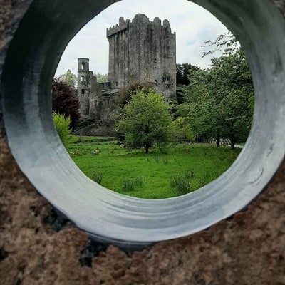 A castle photographed through a hole in a stone wall
