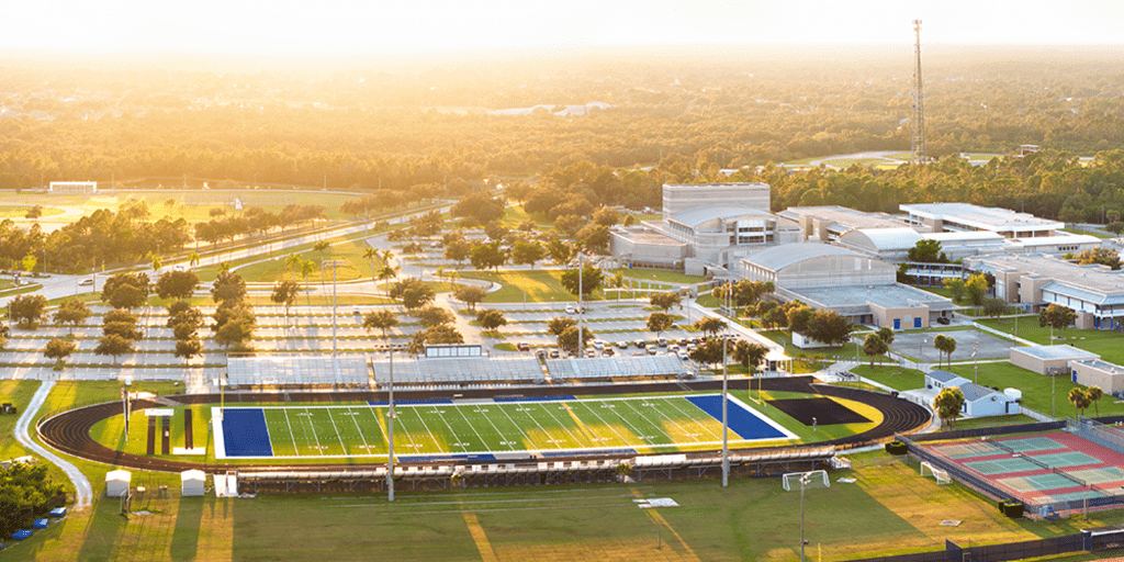 Aerial view of American football stadium, tennis courts and baseball diamond