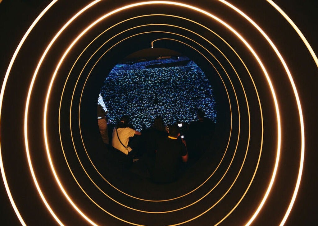 Attendees sitting down and looking at stars through a screen, inside the truck.