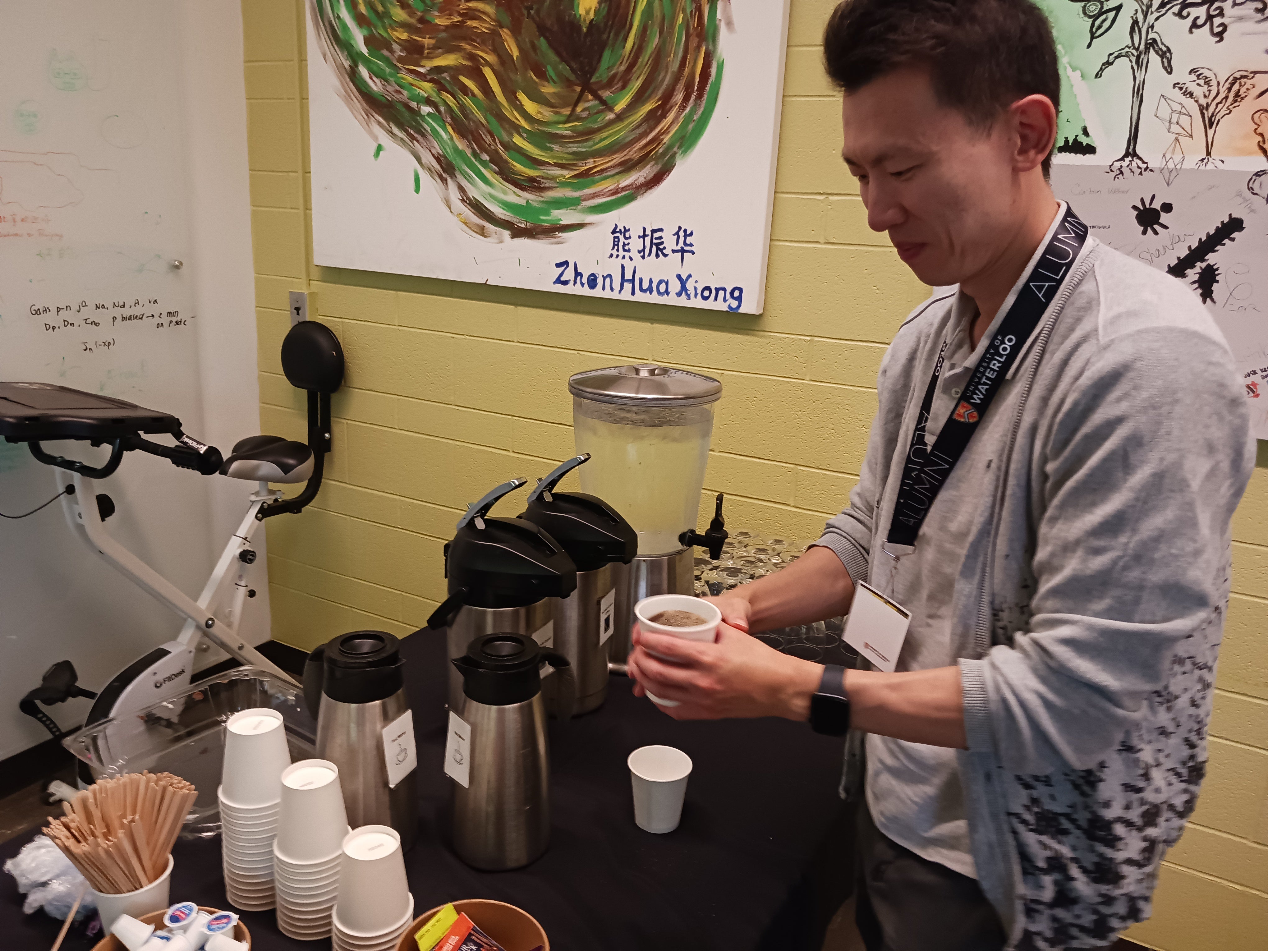 A person at a coffee station, pouring a cup of coffee. 