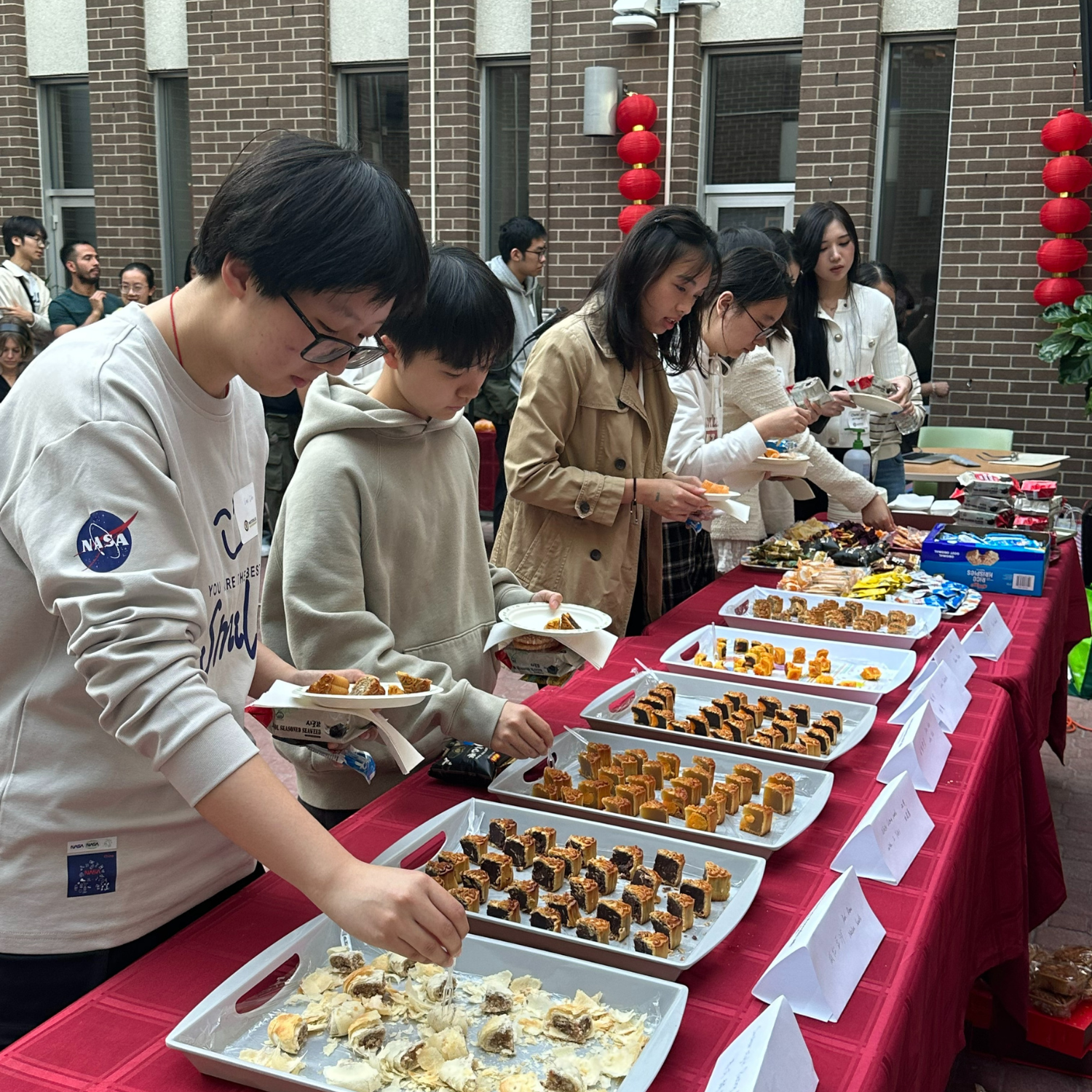 Attendees grabbing moon cakes and other snacks.