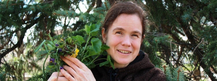 Woman holds a bouquet of wild plants.