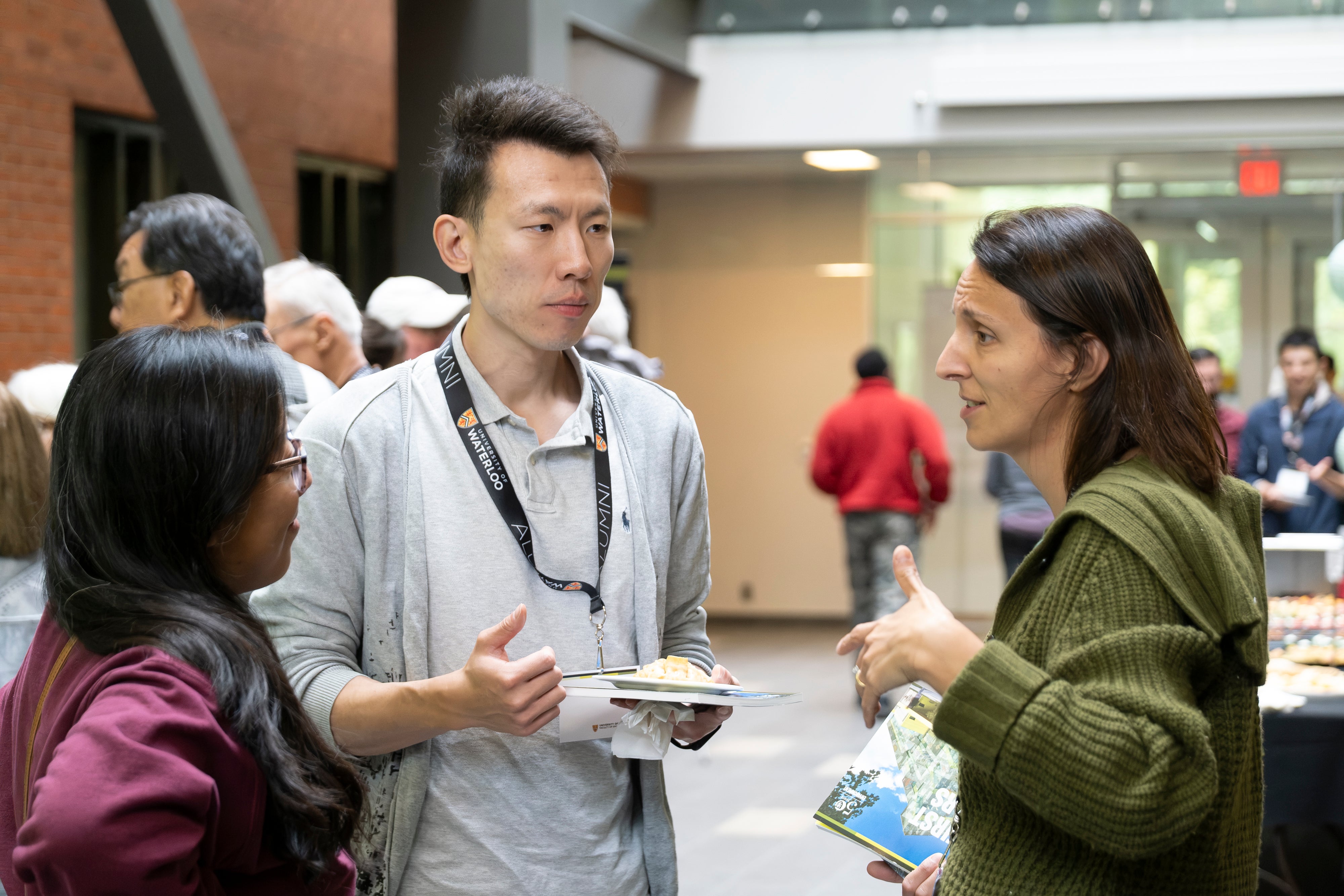 Three people in conversation at a reception. 