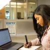 Student working at a desk and on a computer