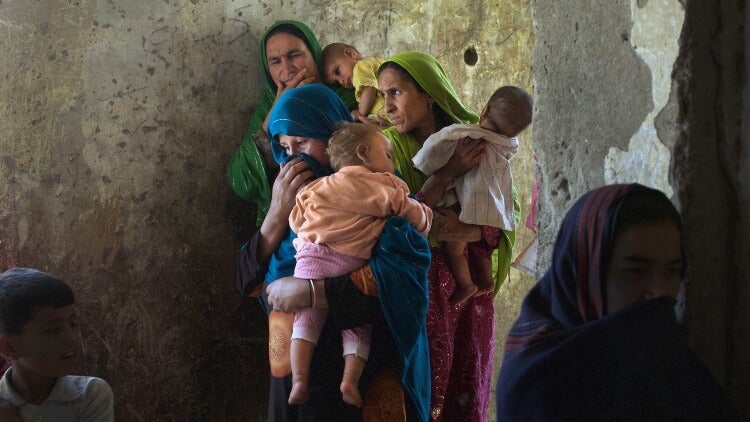 Afghan mothers in an apartment block, holding their children