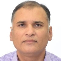 A head-and-shoulders portrait of a middle-aged man with short dark hair against a plain white background.