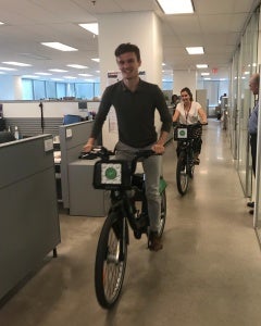 Office worker riding bike in office