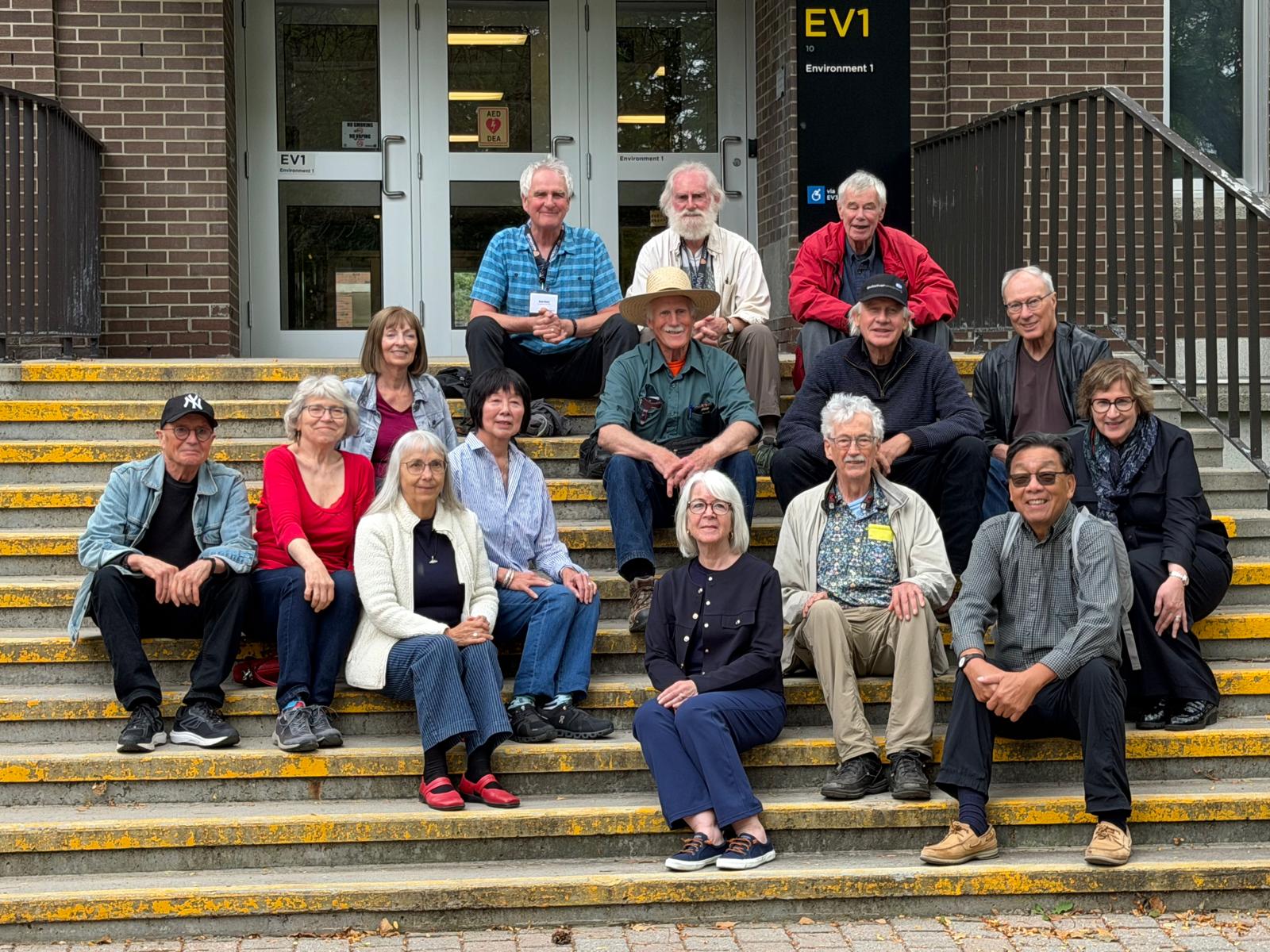 A group of people sitting on steps in front of a building.