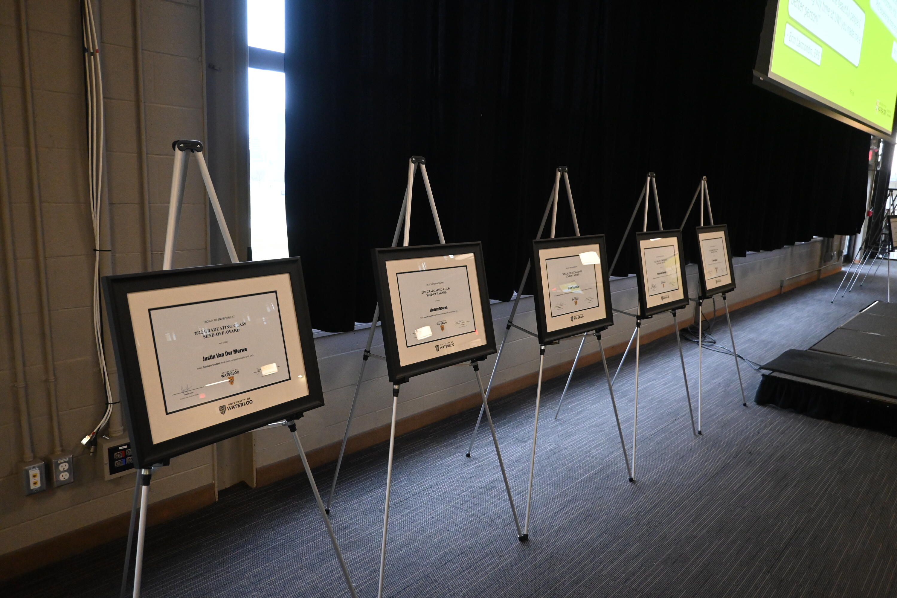 Five award certificates displayed on easels