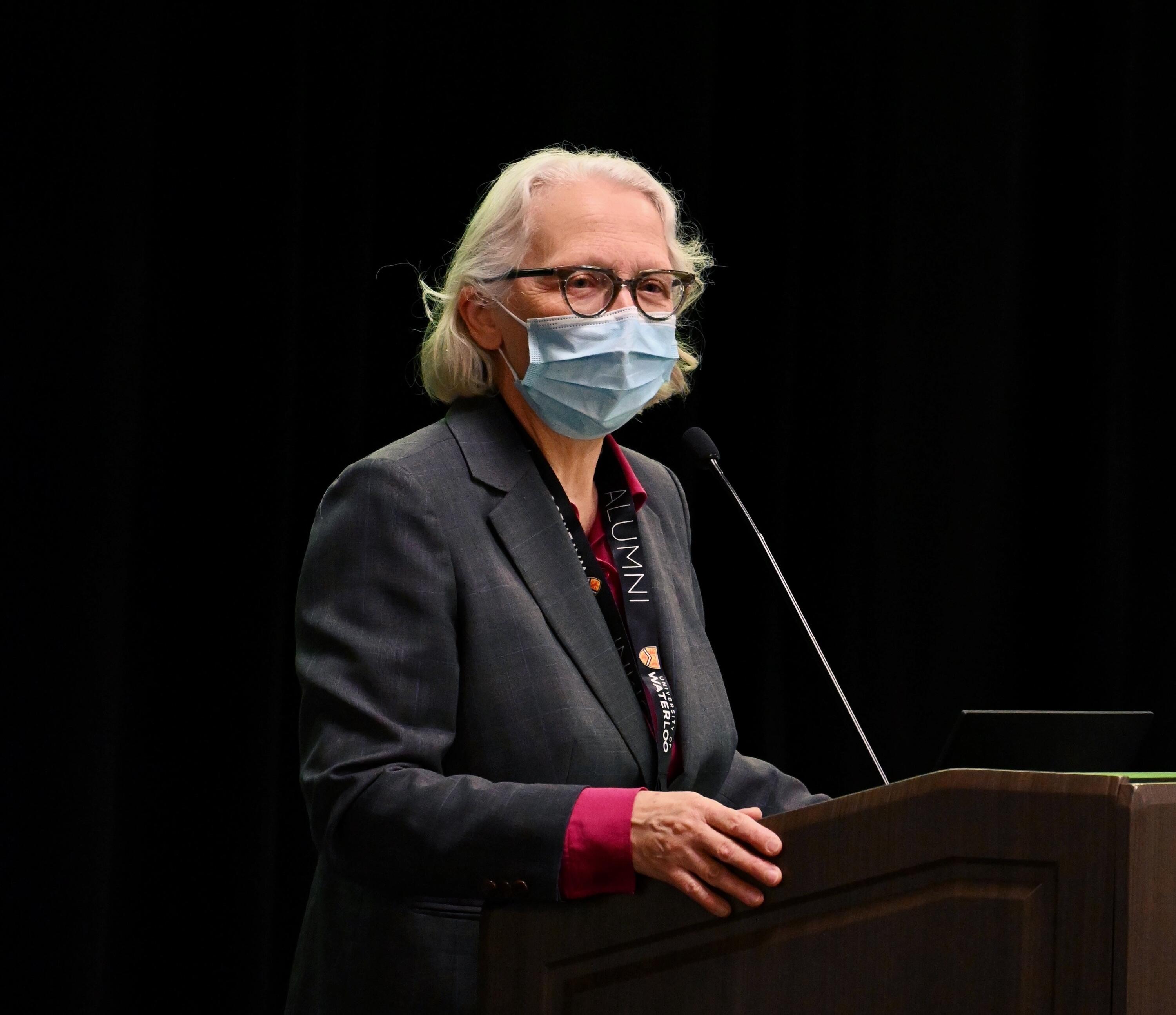 Dean Jean speaking at a podium