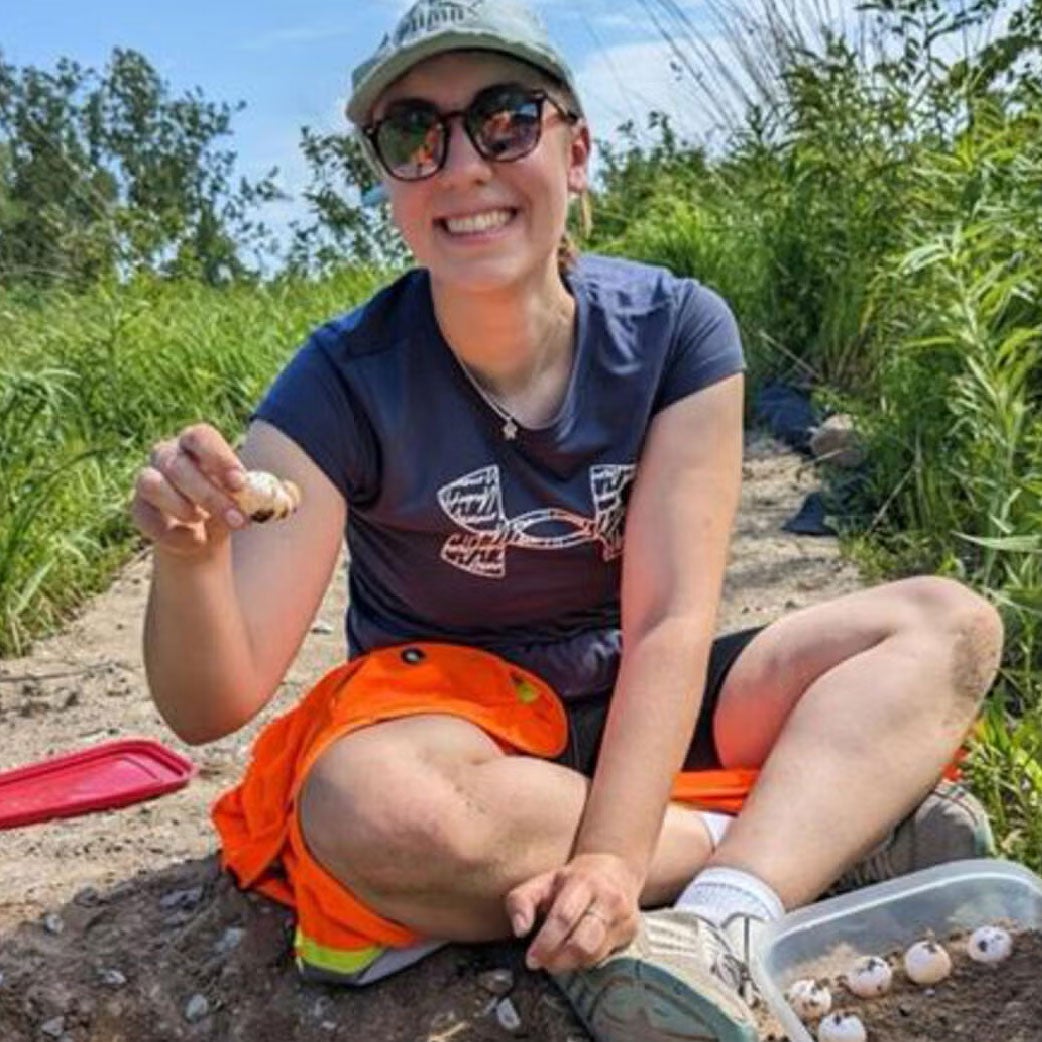 Environment student Katie Kubasta sitting in a field