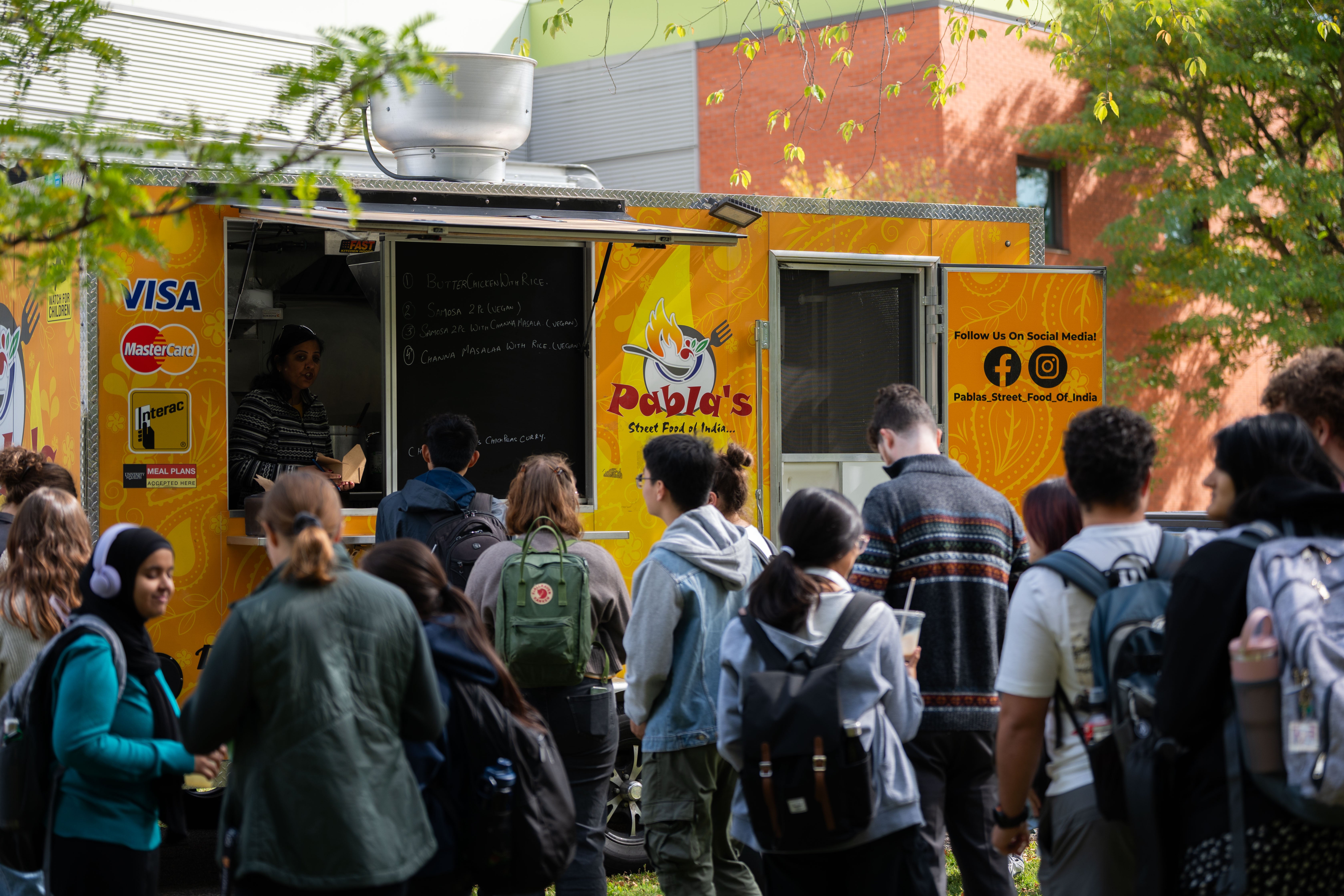 People lined up for food at a truck.