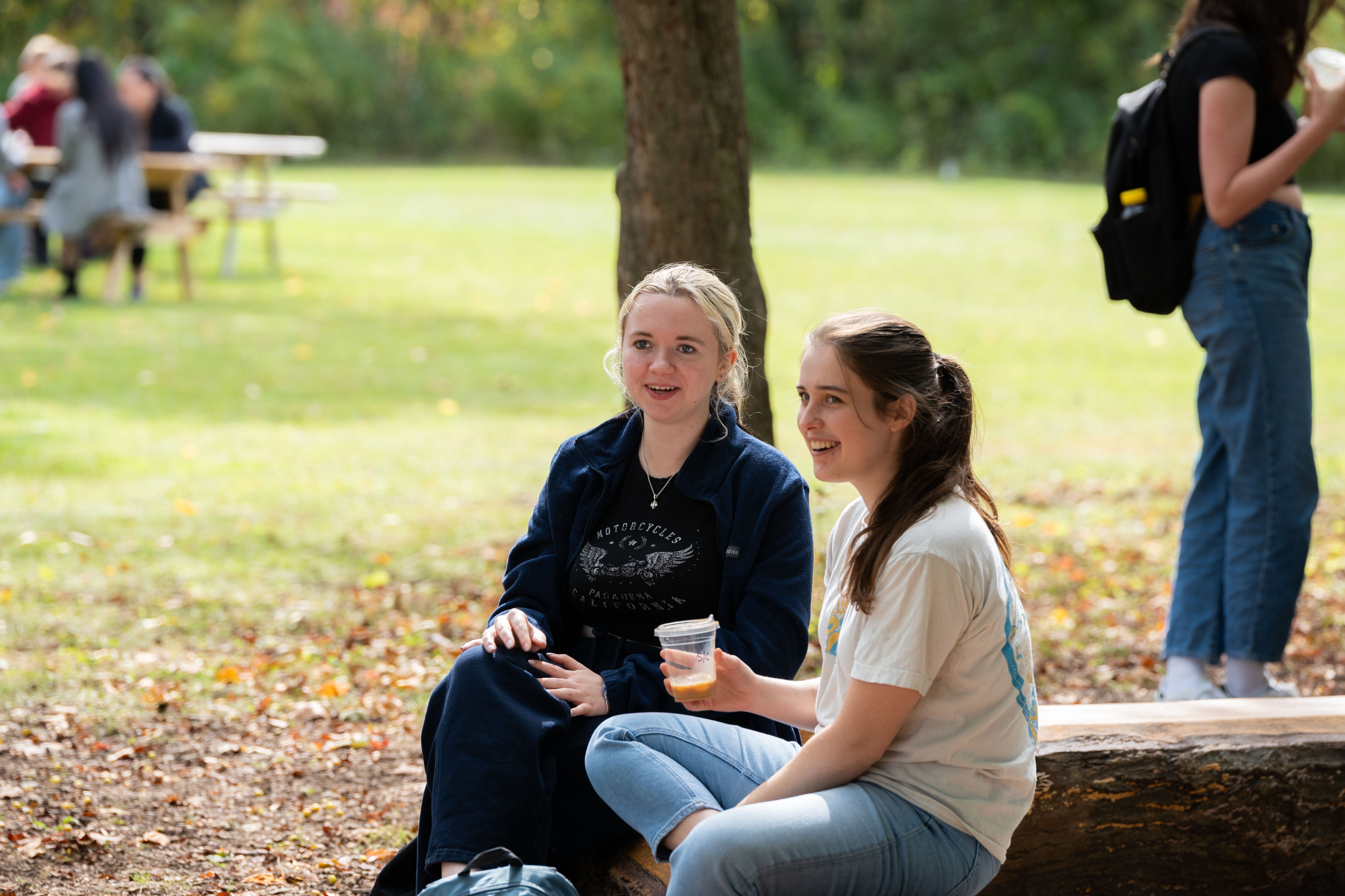 Two people talking on a bench.