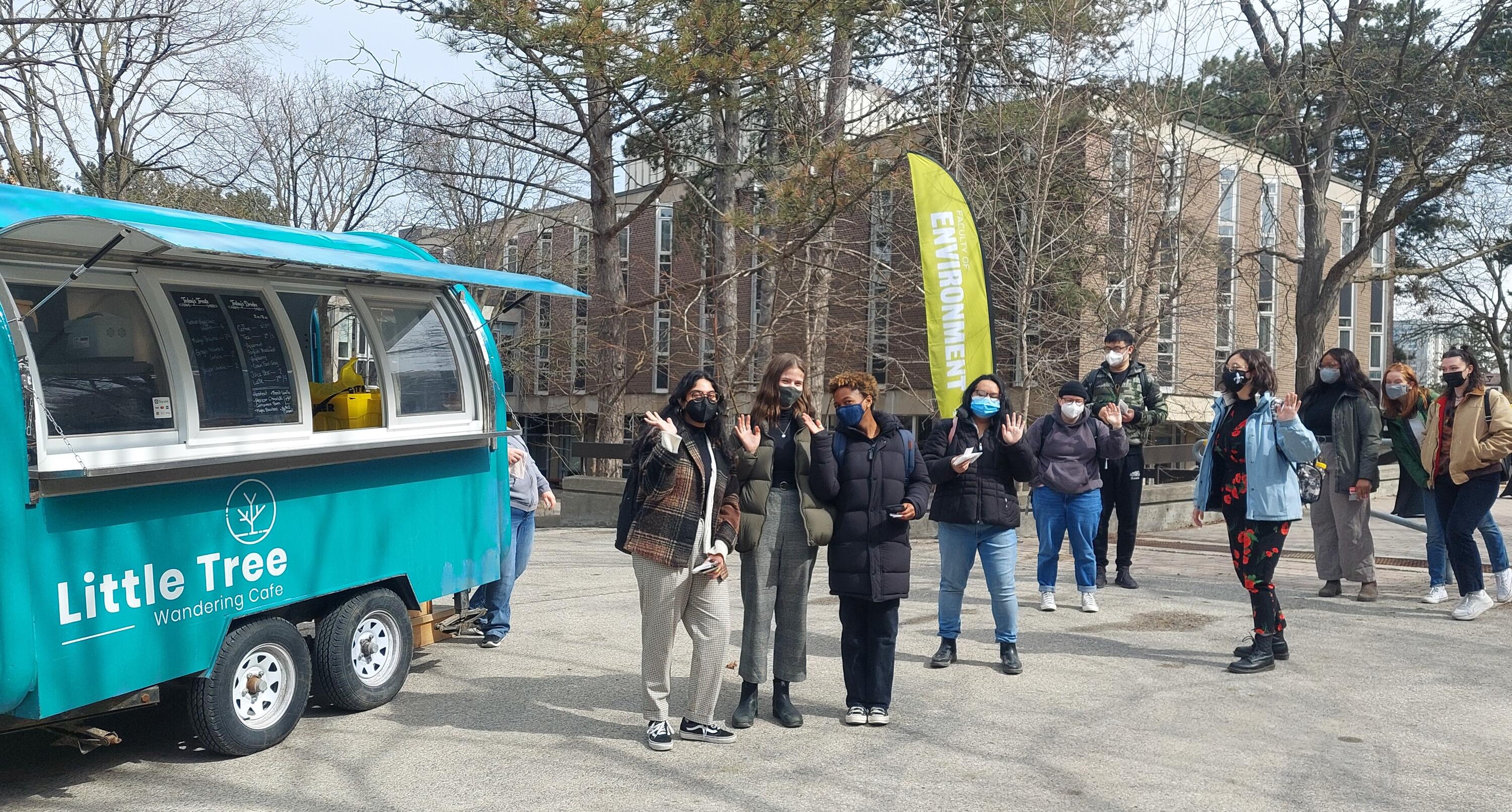 Students waving in line for a food truck