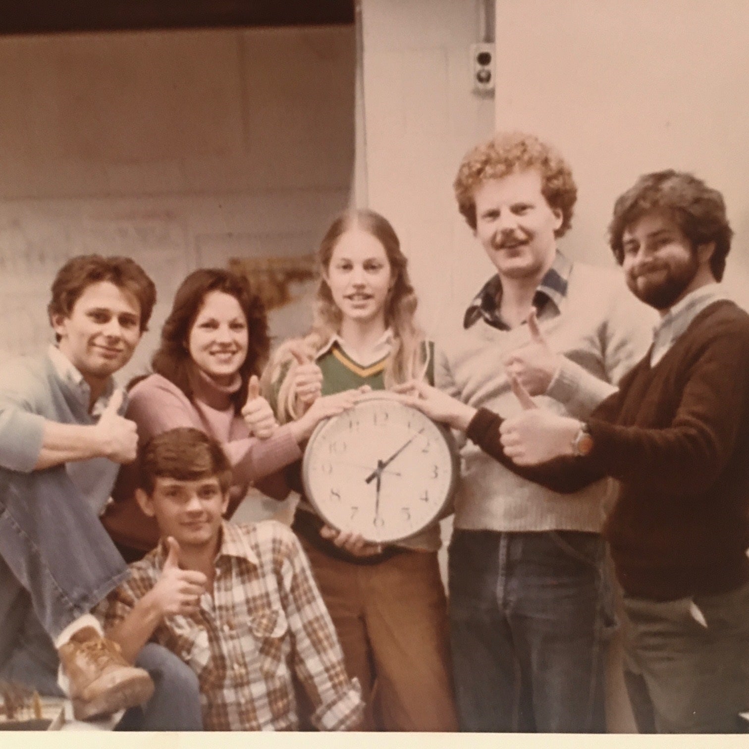 Planning Class of '81 holding up a clock after a long night of PLAN 300