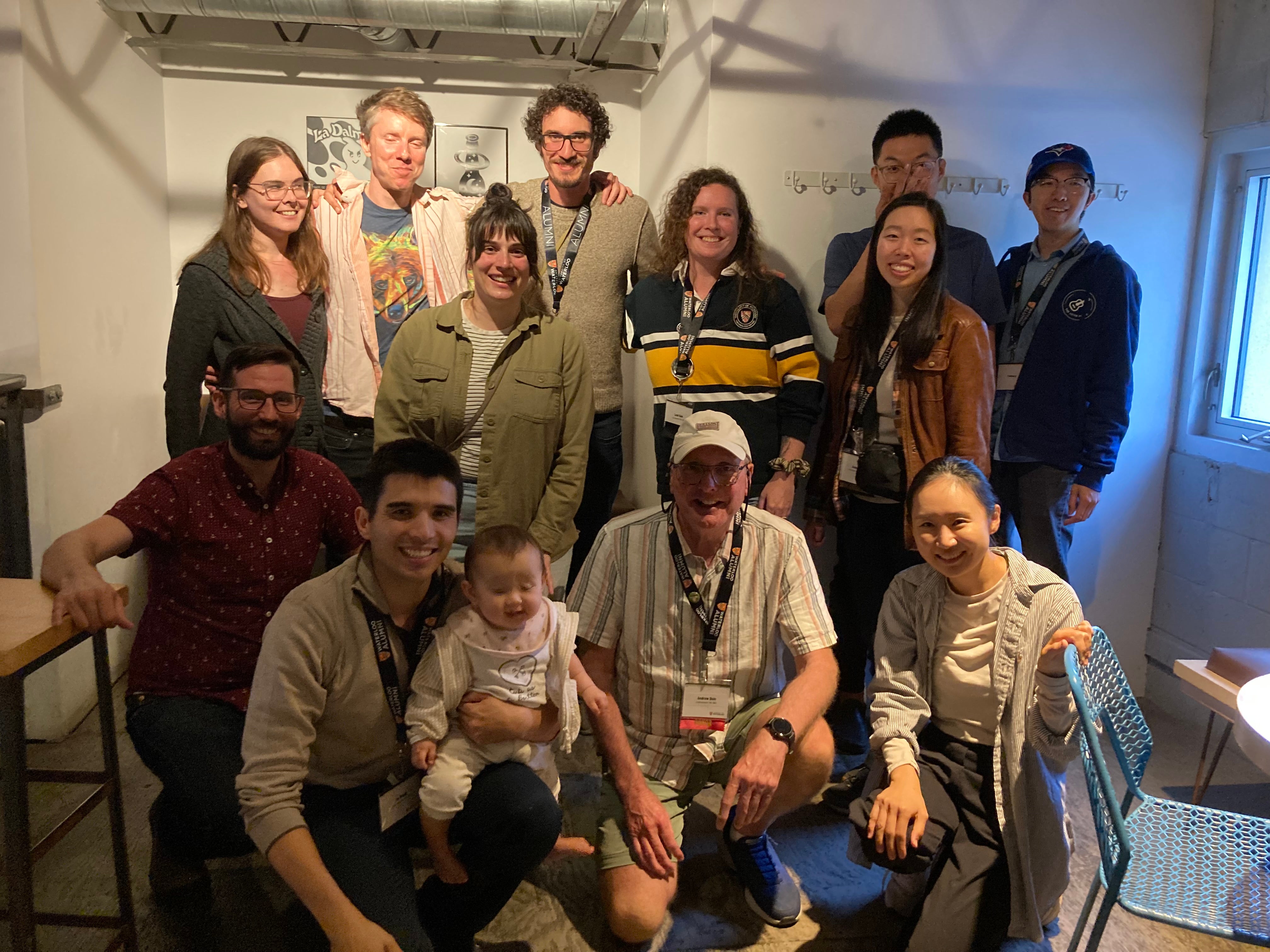 A group of 11 people lined in rows smiling. 