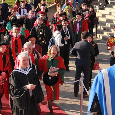 Dean Jean laughing in a crowd at convocation