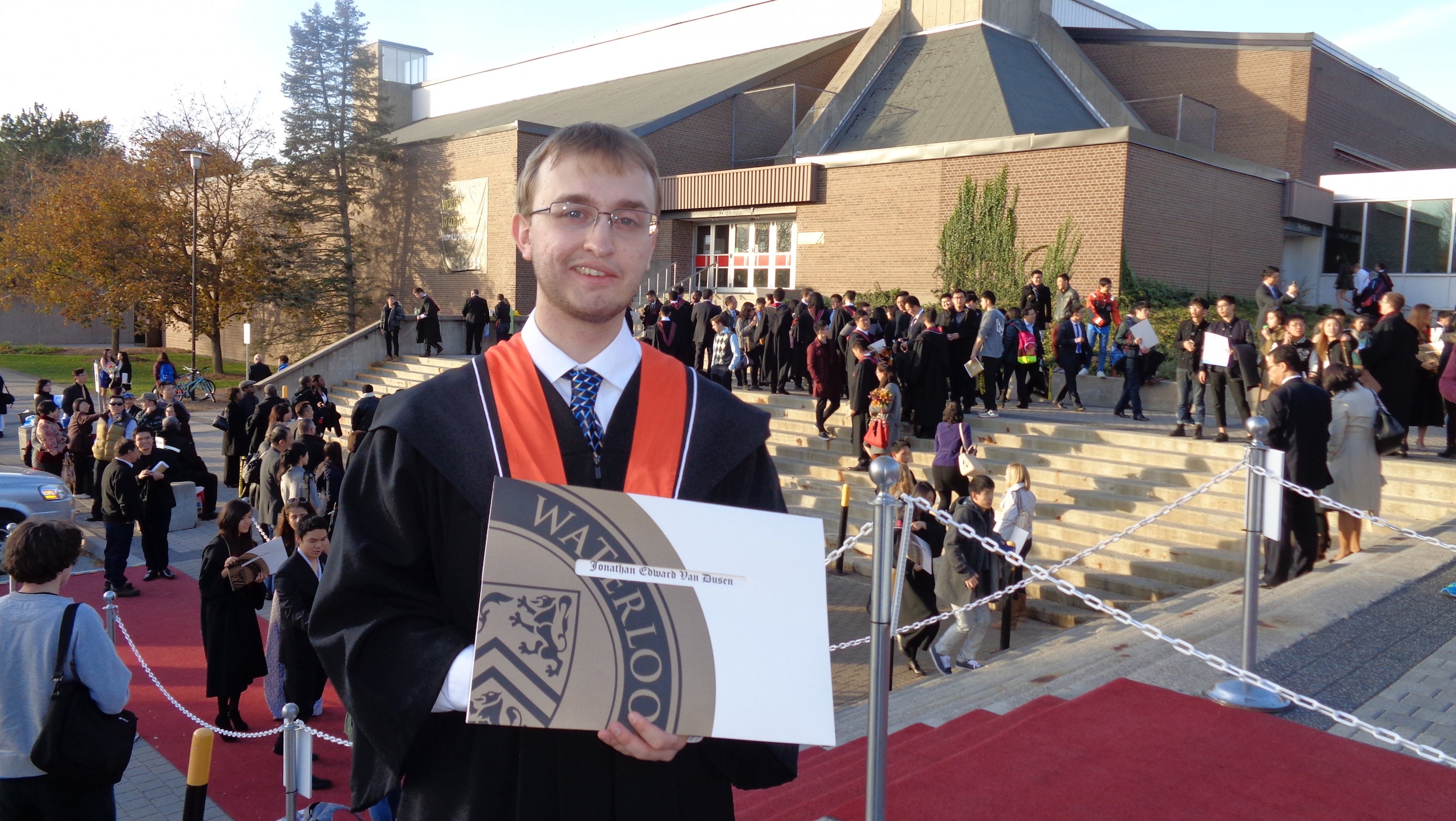 Jonathan Van Dusen holding his diploma.
