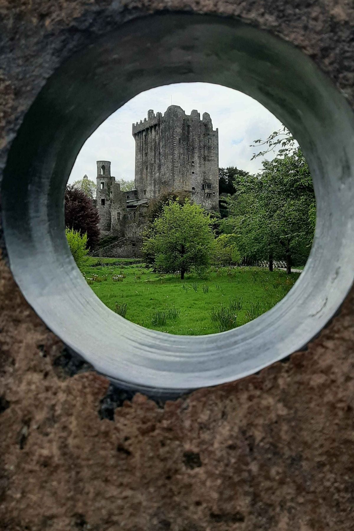 A castle photographed through a hole in a stone wall