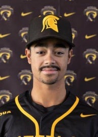 Man posing for picture in baseball hat and jersey