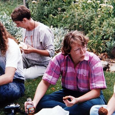 Dean Jean sitting with a group of people in the 1990's