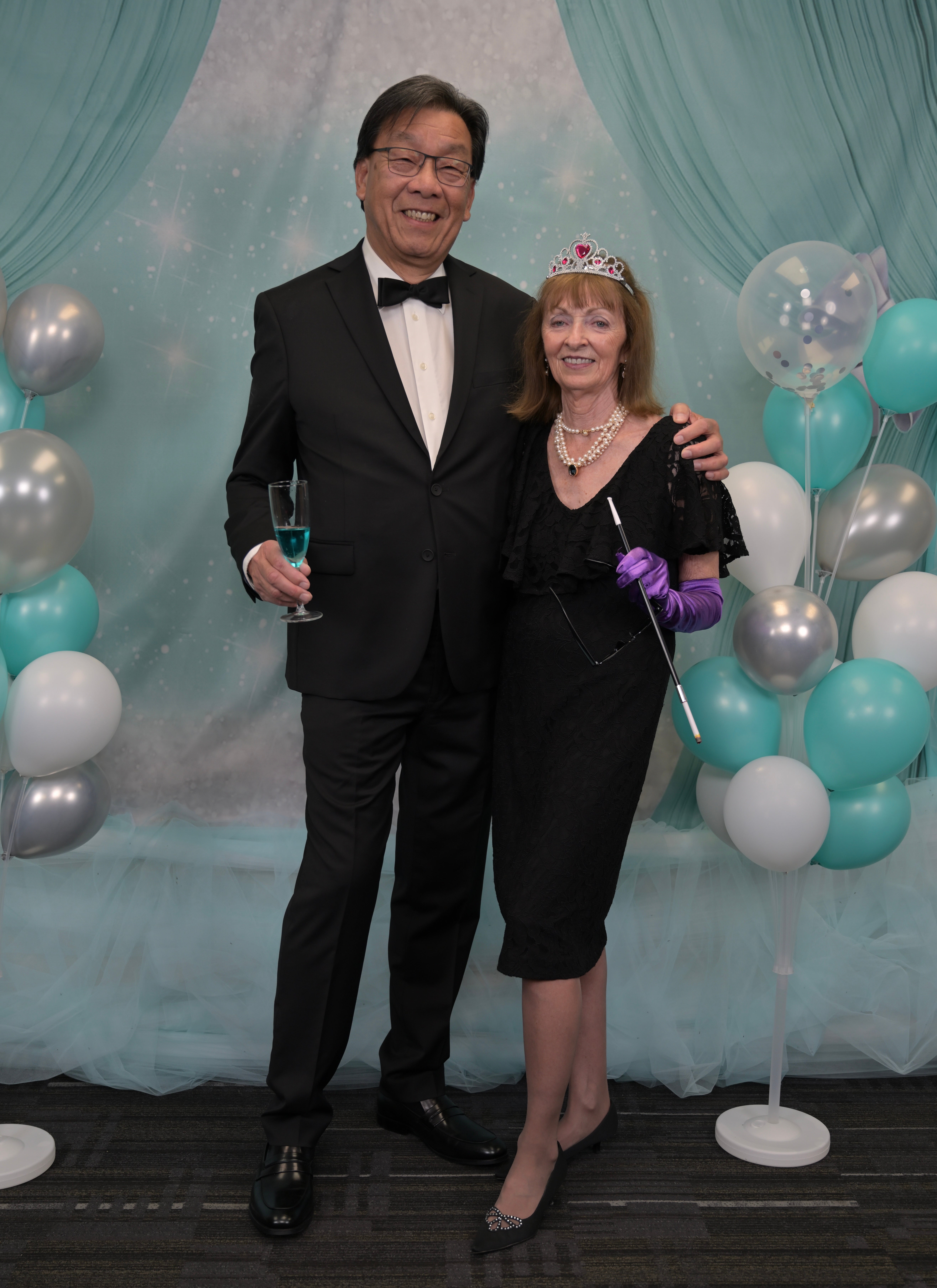 Man and woman in formal wear hold champaign glasses