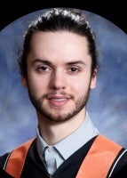 Man smiling for a graduation picture