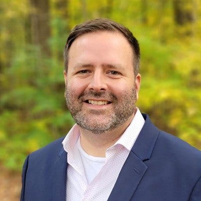 man  in white shirt and blue blazer smiling