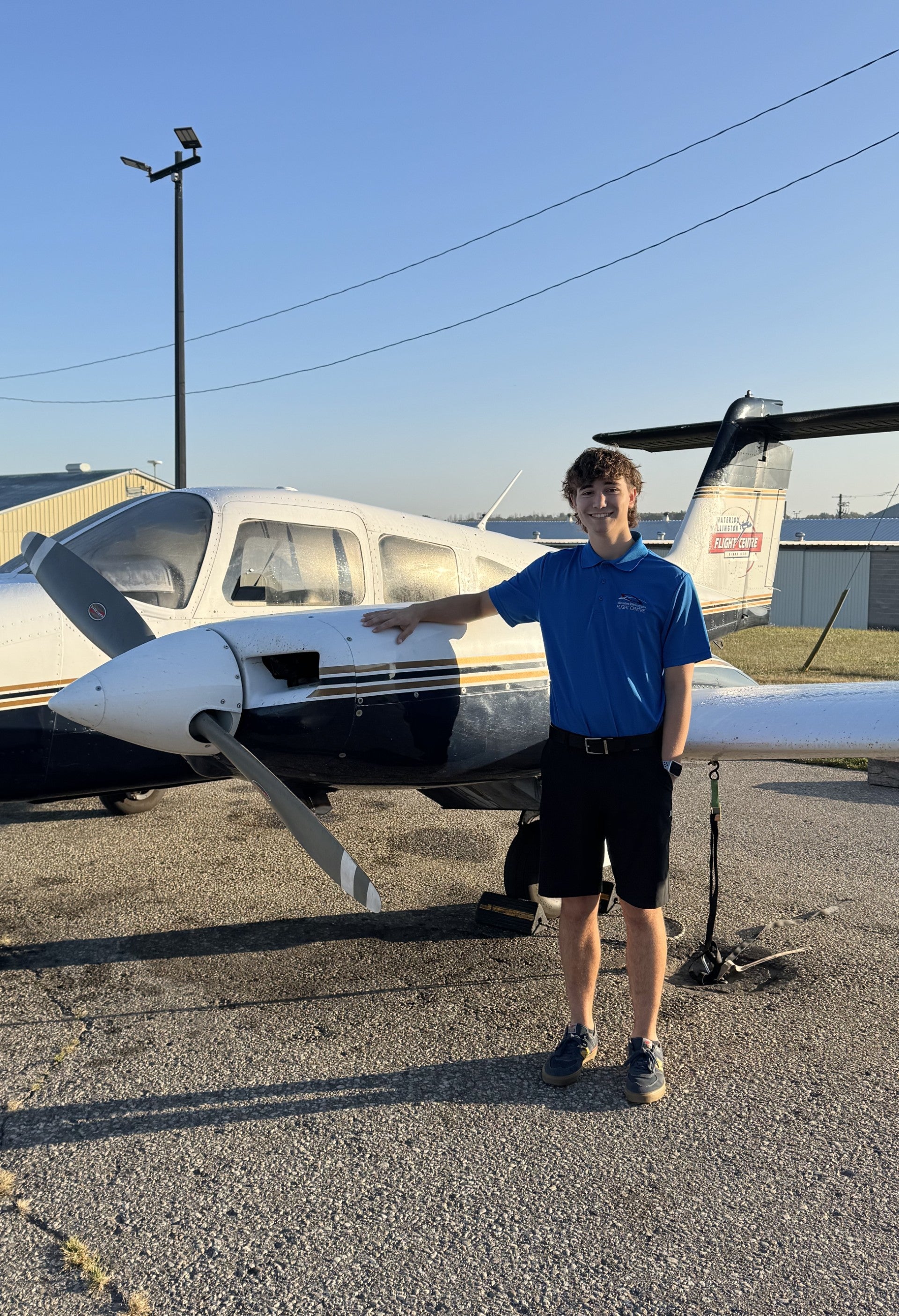 Sam smiling next to a plane