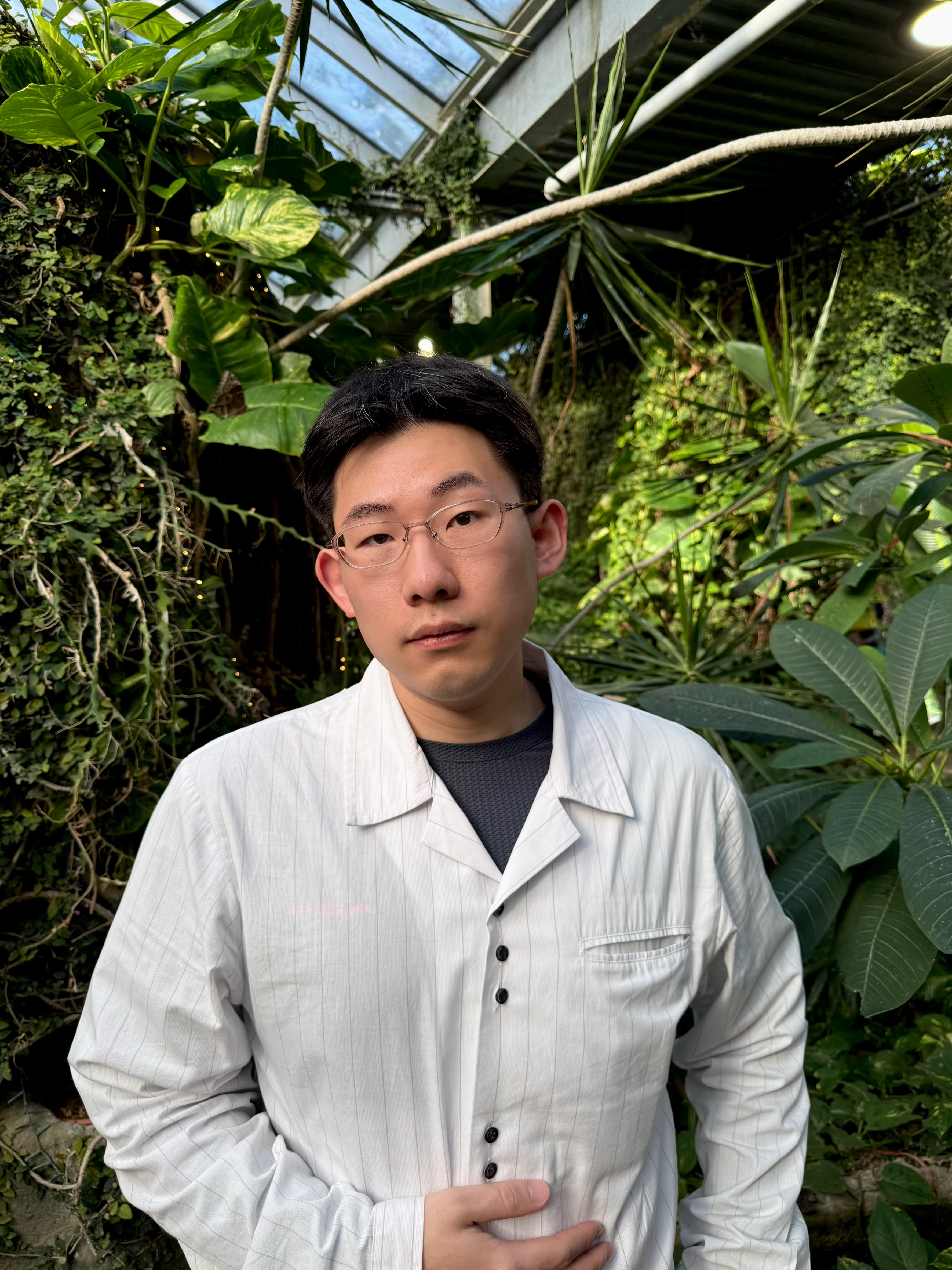 east asian young man in a wwhite shirt with glasses 