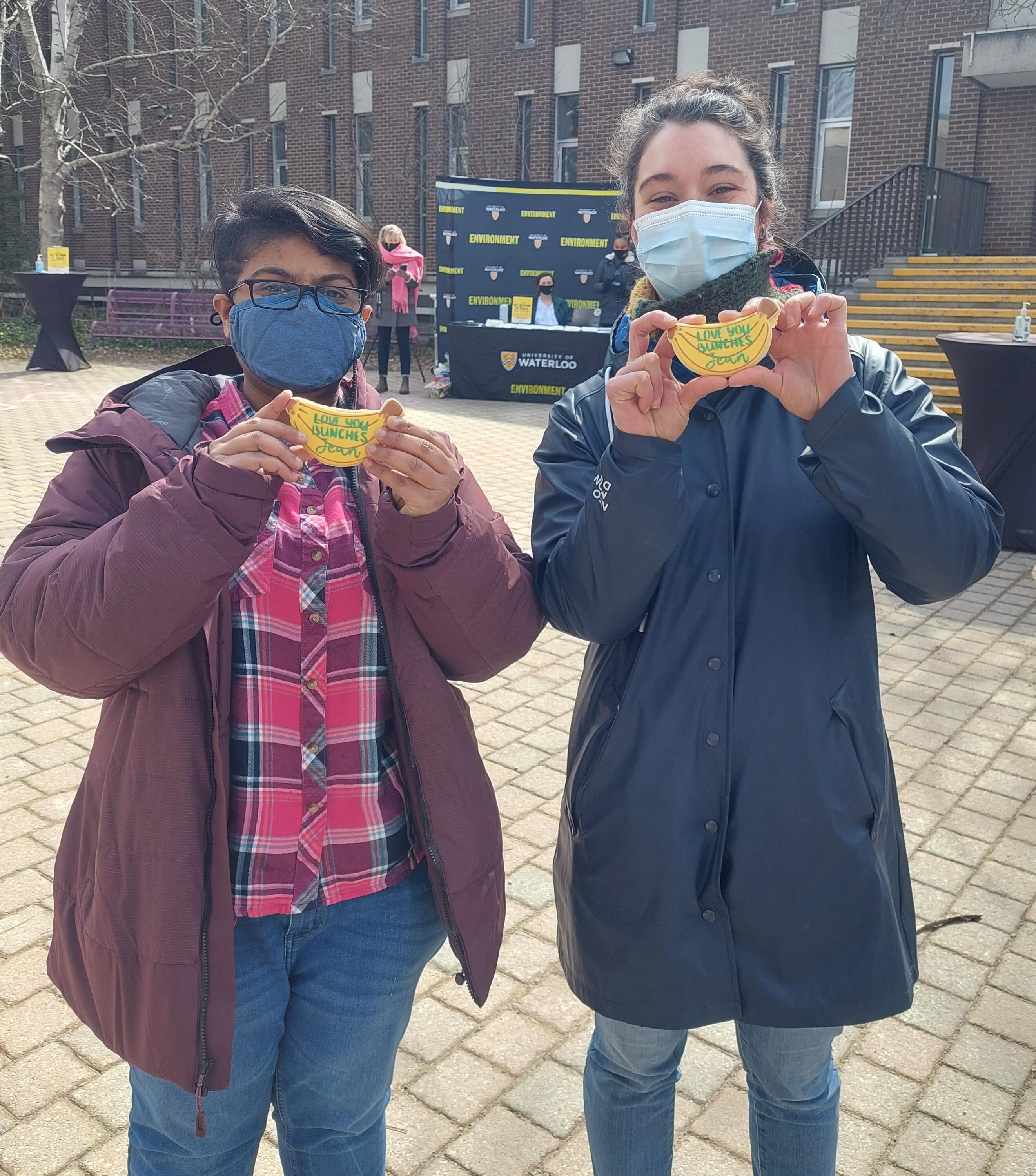 Two students holding banana shaped cookies