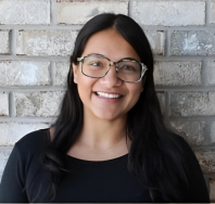 a women wearing black dress and glasses with a smile on her face