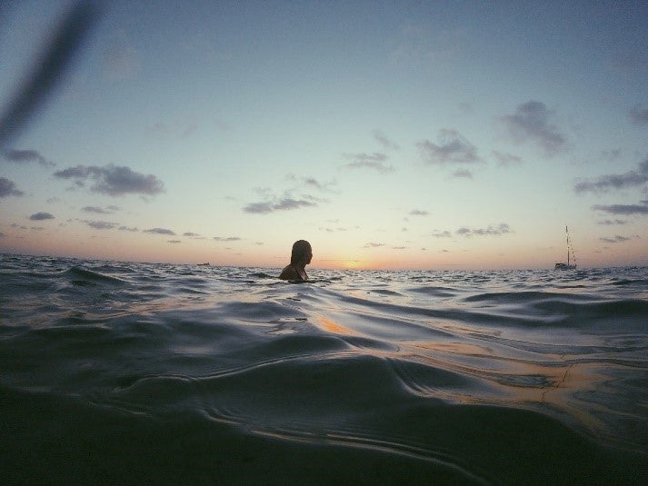Girl swimming with during sunset