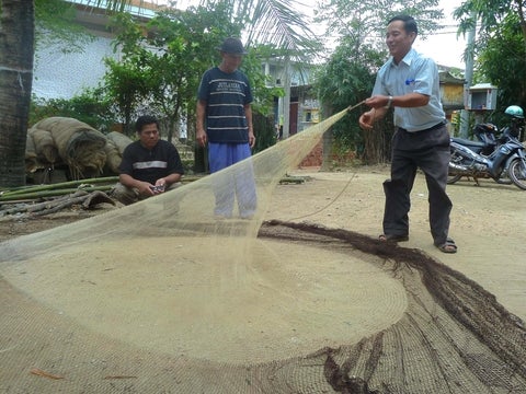 A fisher demonstrating how to set a fishing net.