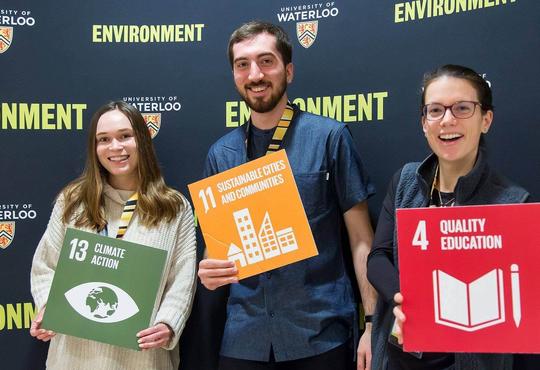 Researchers holding three of the 17 SDGs sign