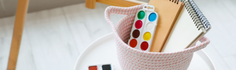 Paint supplies stored in a white basket