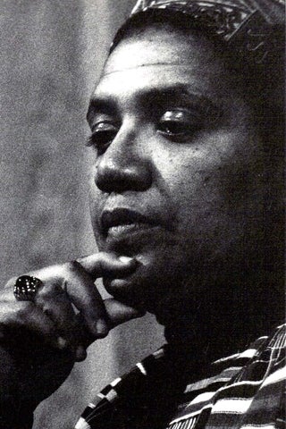 A close up black and white image of a black woman facing the left with her fingers on her chin.