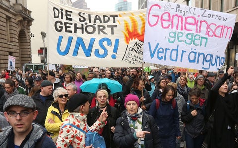 A photo of a protest with two large signs written in German.