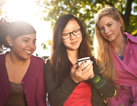 three girls using a smartphone