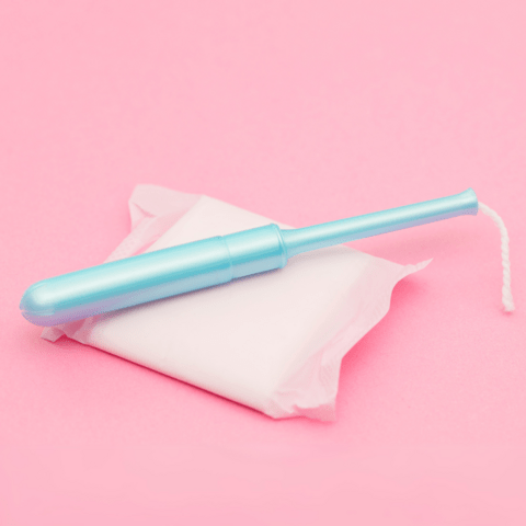 A blue tampon and pad on a pink background