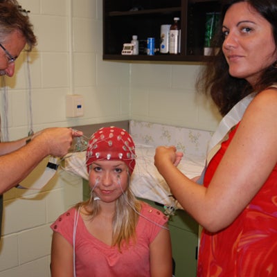 A female participant is being connected to the electrodes for the lab.